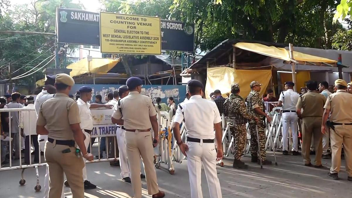 Security personnel and officials outside a vote counting centre during WB