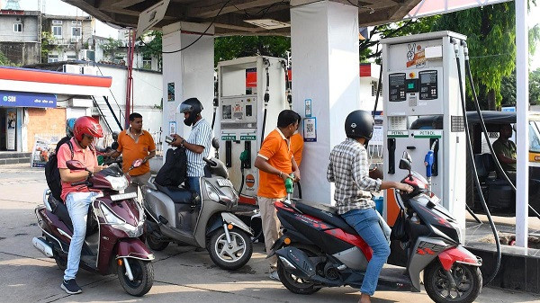Workers fill fuel in scooties at a Petrol Pump
